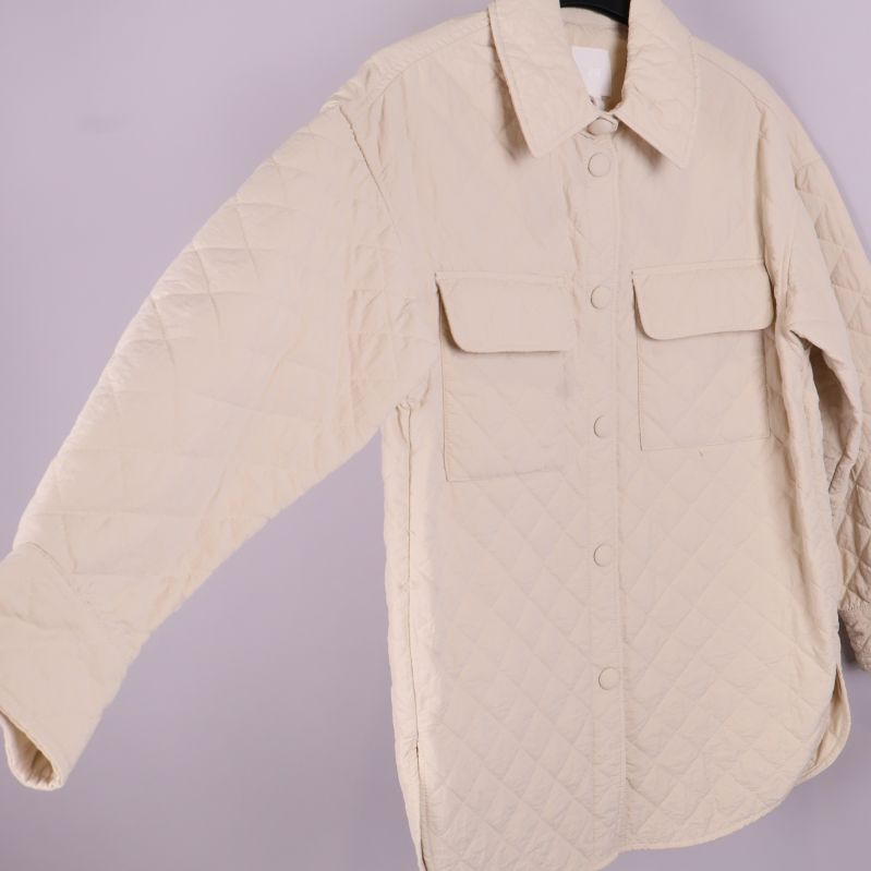 Quiltad beige overshirt fotograferad från sidan