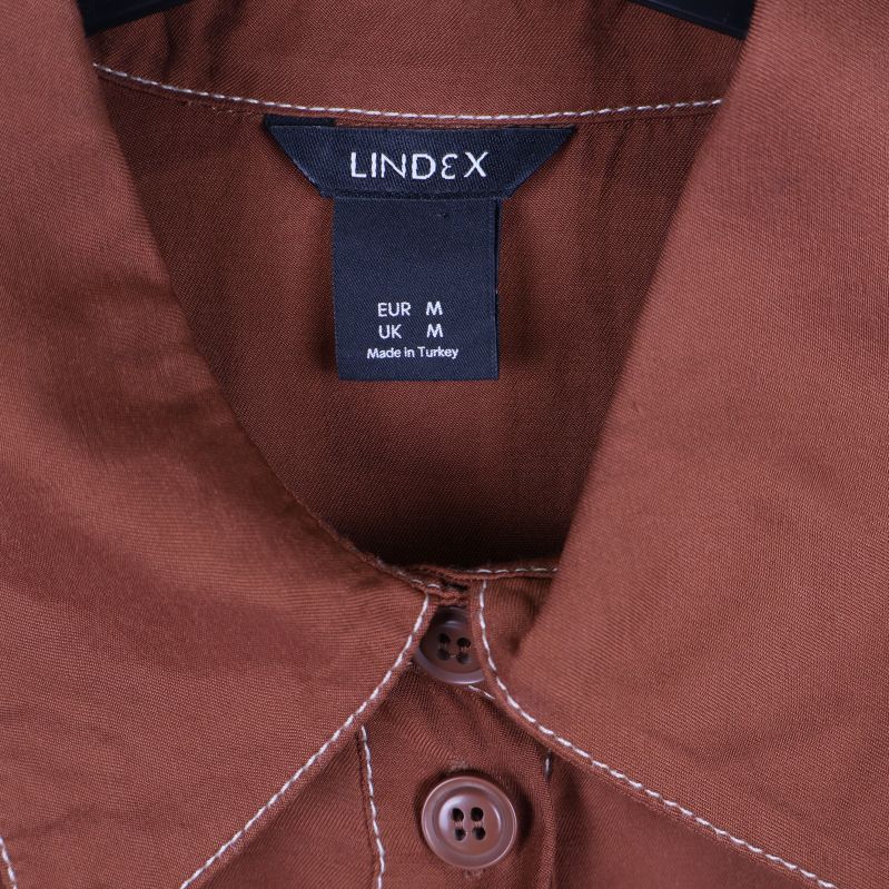 Närbild på Lindex-etikett i skjortkragen