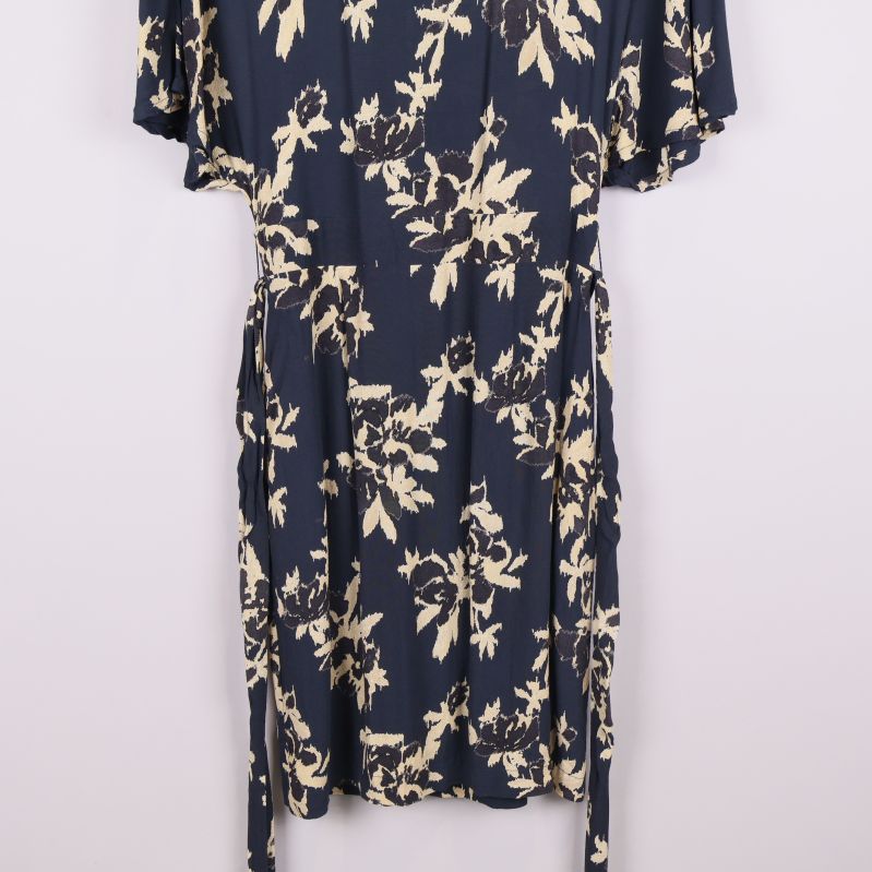 Nedre delen av klänning med knytband synligt