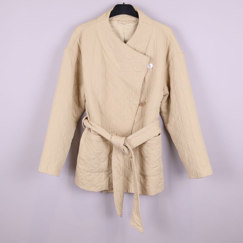 Framsida av beige quiltad jacka med midjeband