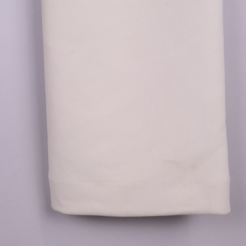 Närbild av benslut på ljusbeige byxa