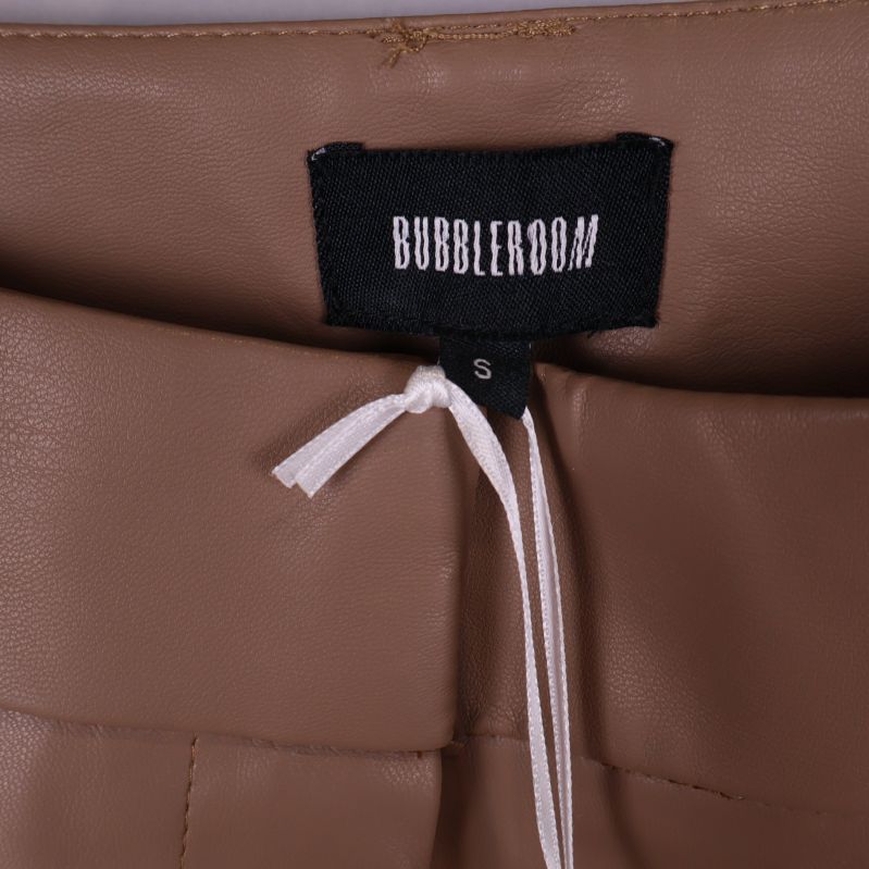 Närbild av Bubbleroom logotyp på etikett i linning