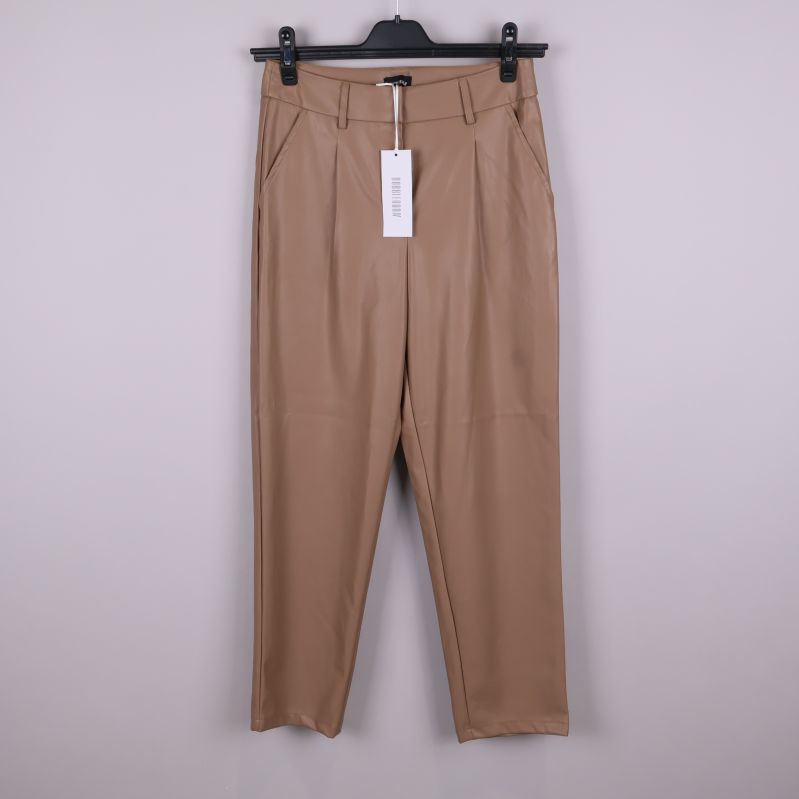 Beiga byxor i skinnimitation upphängda framifrån