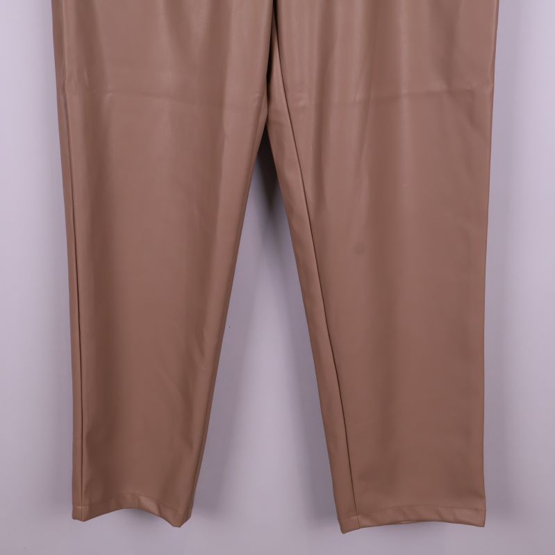 Närbild på nederdelen av beiga byxben