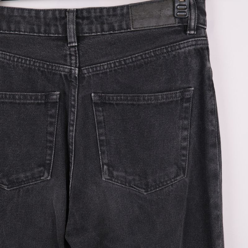 Närbild på bakfickor och midja av svarta jeans