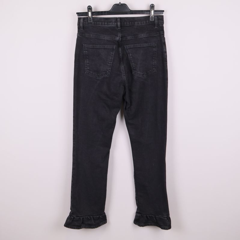 Svarta jeans med volangkant upphängda bakifrån
