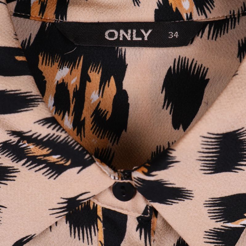 Närbild på krage och knapp av leopardmönstrad skjorta