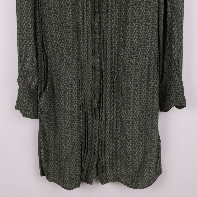 Närbild på ärmslut och knäppning av skjortklänning