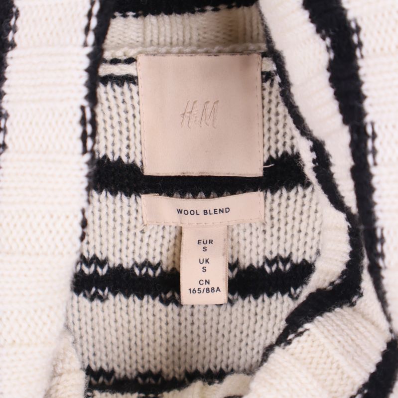Närbild på H&M märkning och etikett inuti polokragen