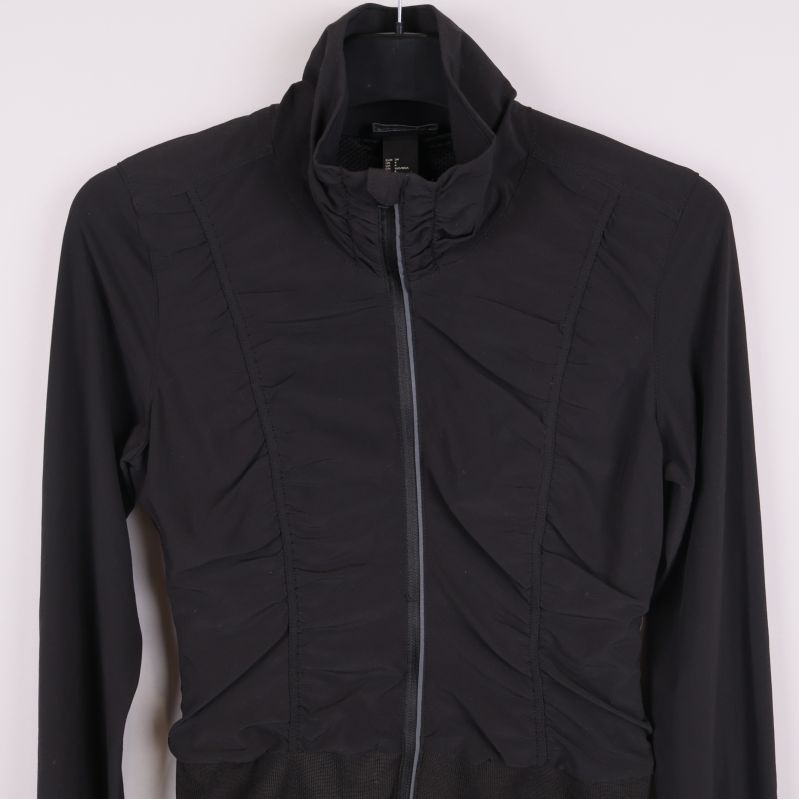 Framsida av svart sportjacka, övre del och dragkedja