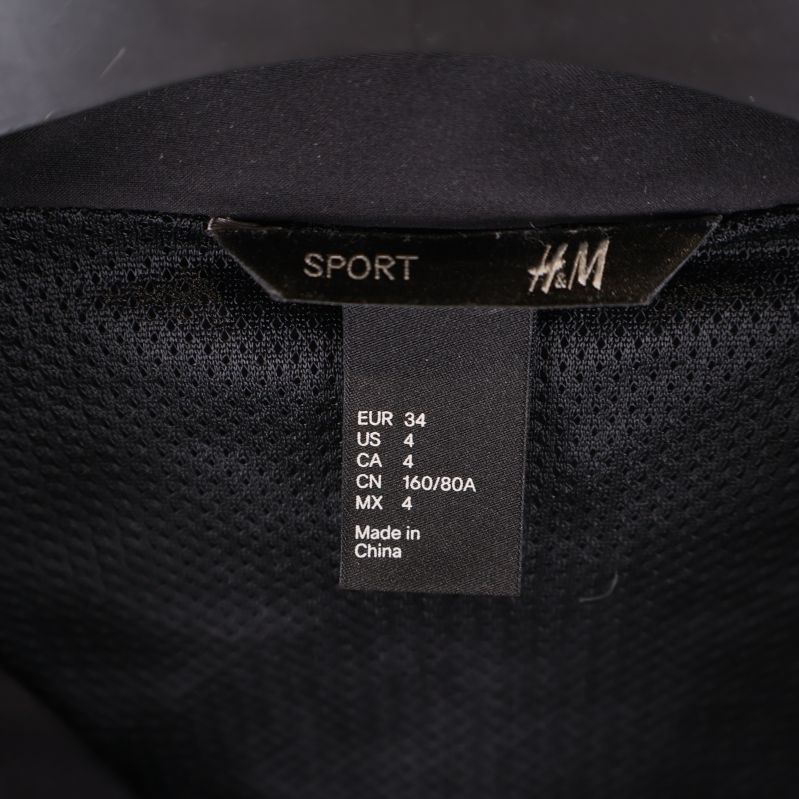 H&M sportetikett och storlekstagg EUR 34 på svart meshfoder