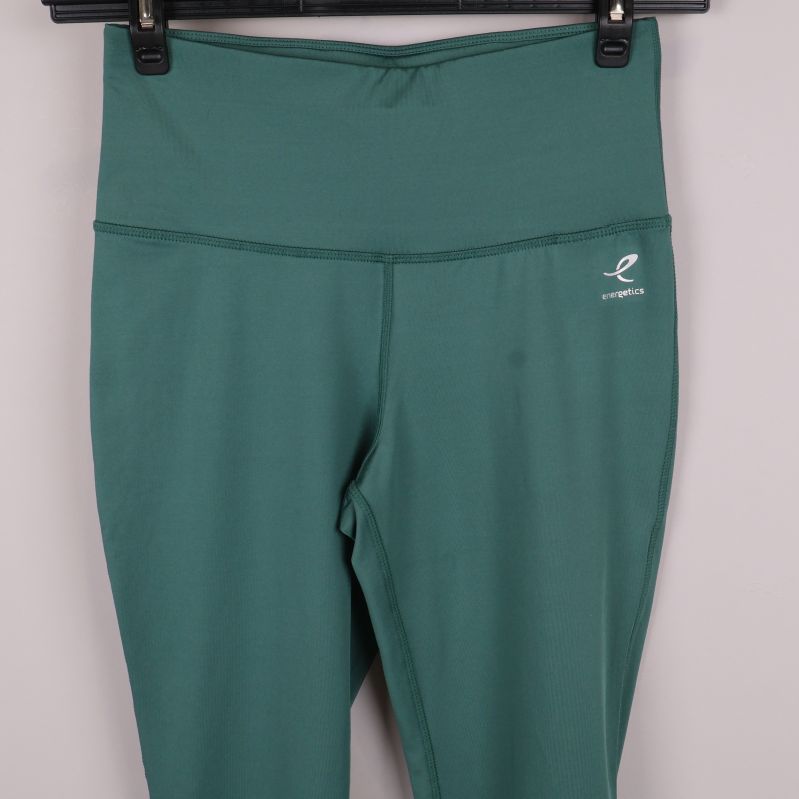 Närbild på midja och logga på gröna träningstights