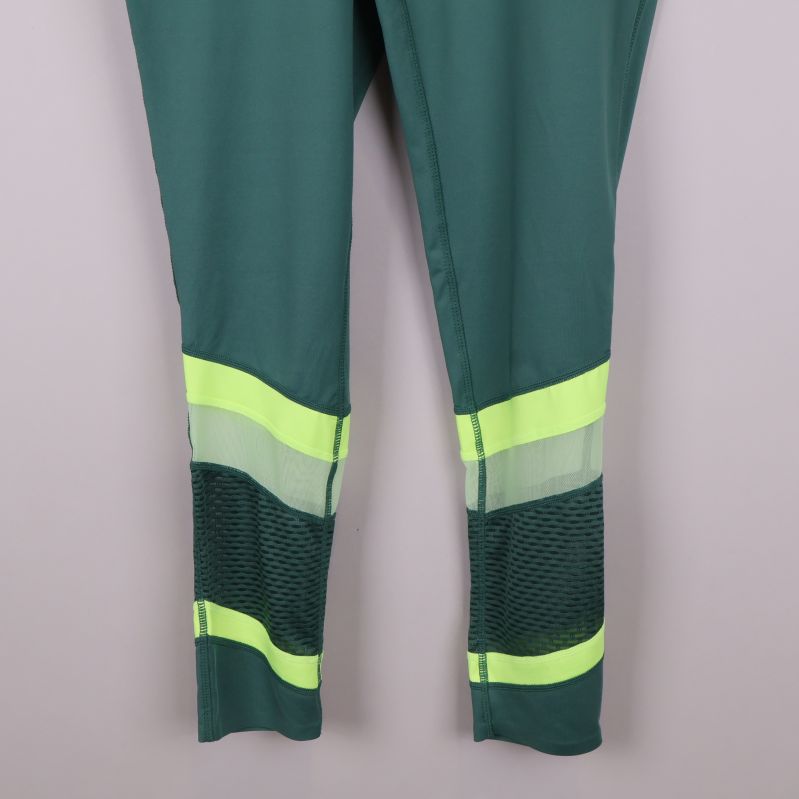 Närbild på neon- och meshdetaljer på benen på tightsen