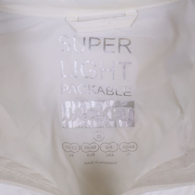 Insida av jacka med texten super light packable jacket och storleksangivelse