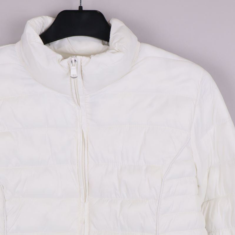 Detaljbild av jackans krage och dragkedja i vitt