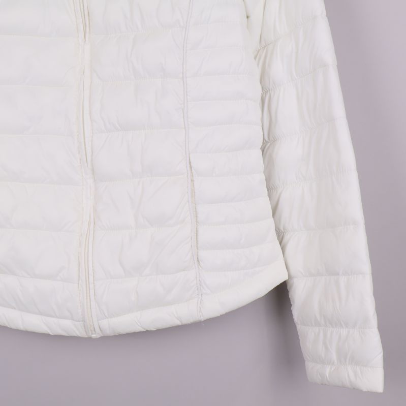 Närbild av jackans nederkant med rak fåll och quiltning i vitt tyg