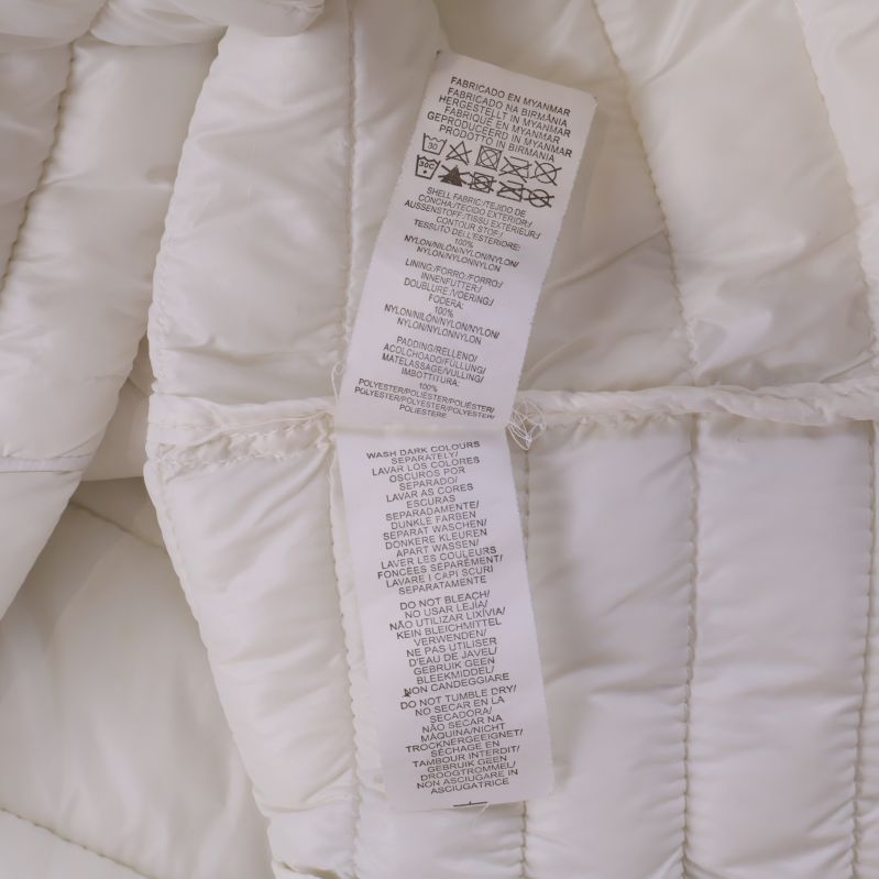 Vård- och materialetikett med detaljer för jackans material och skötsel