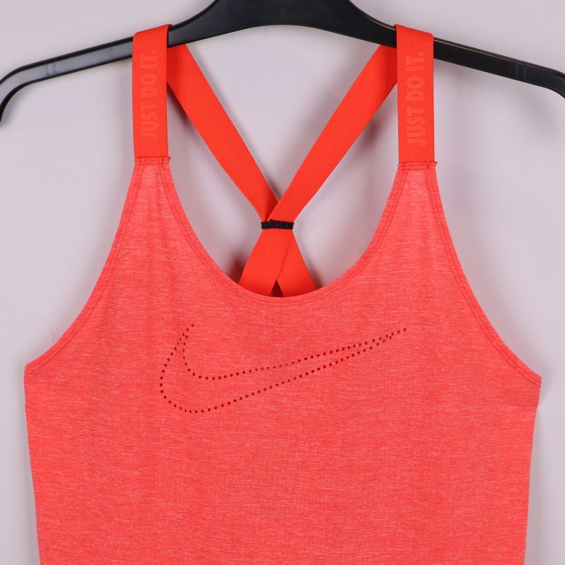 Närbild av framsidan på orange sporttopp med prickad Nike-logga