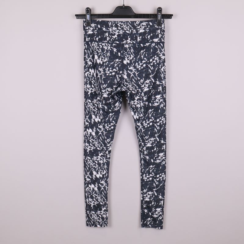 Baksida av svartvita mönstrade träningstights på galge