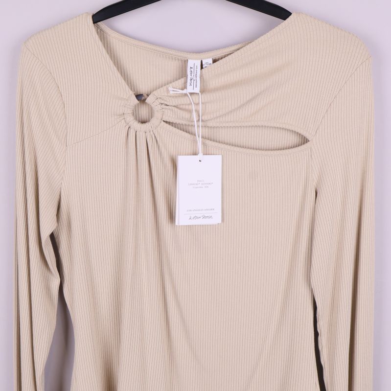 Övre delen av ljusbeige topp med ringdetalj