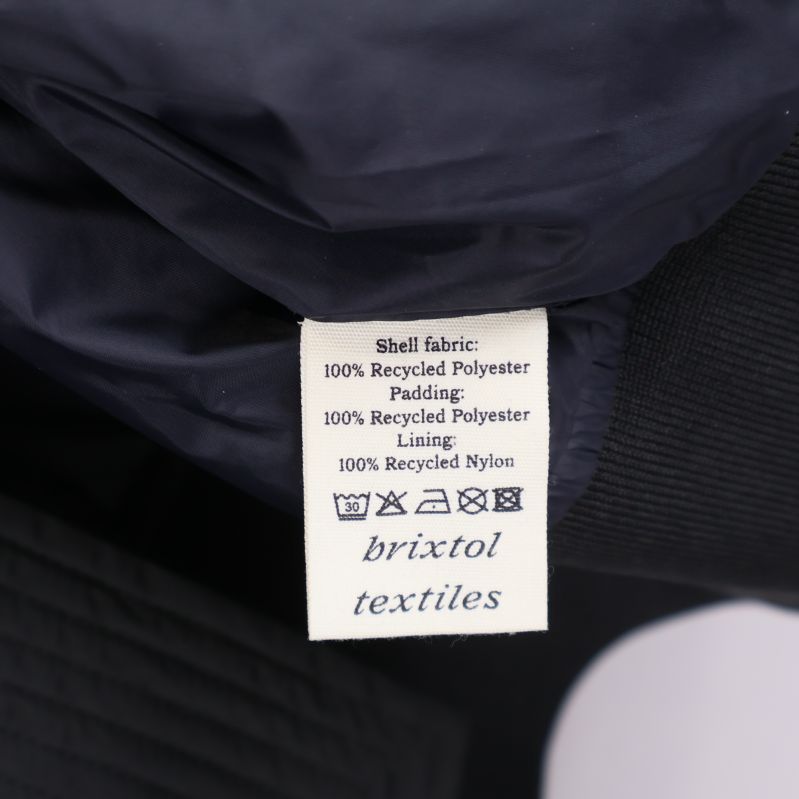 Materiallapp på insidan, visar återvunnen polyester och nylon