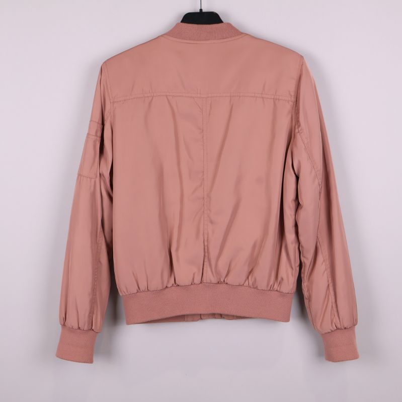 Baksidan av gammelrosa bomberjacka med ribbad nederkant