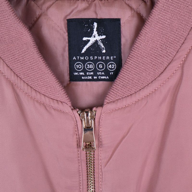 Närbild på krage och etikett på gammelrosa bomberjacka