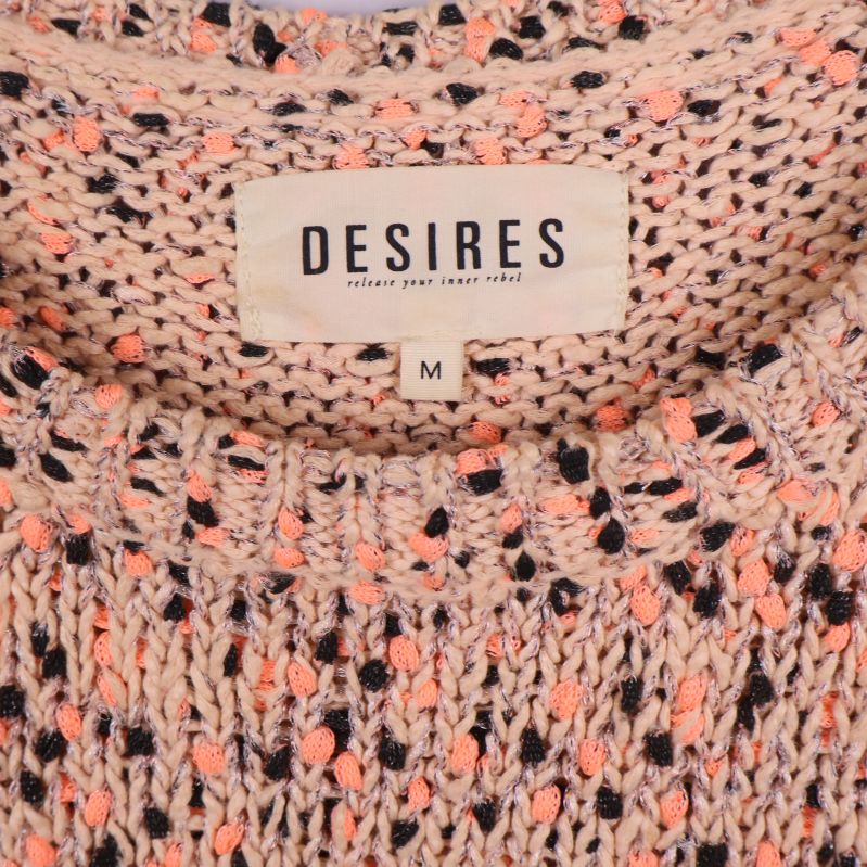 Närbild på Desires-märke i tröjans halsringning