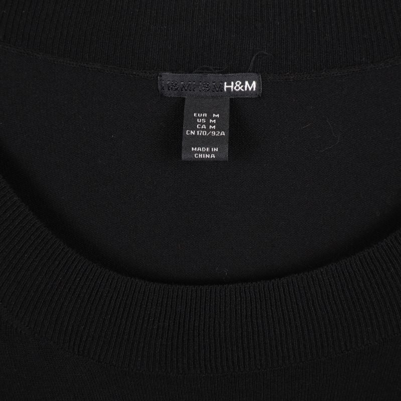 Närbild på H&M-etikett i svart tunika
