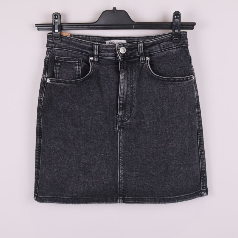 Framsidan av svart denimkjol med fickor