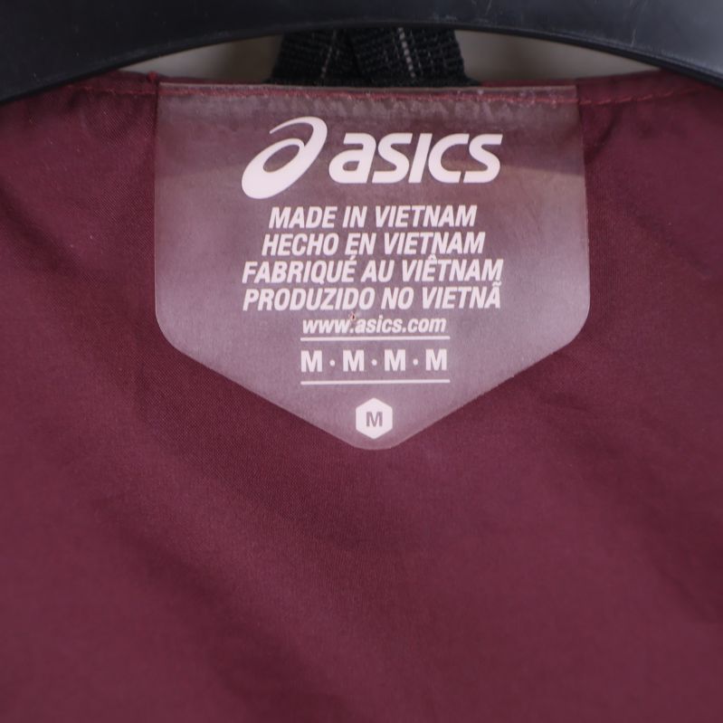 Närbild på Asics etikett och storlekslapp inuti väst