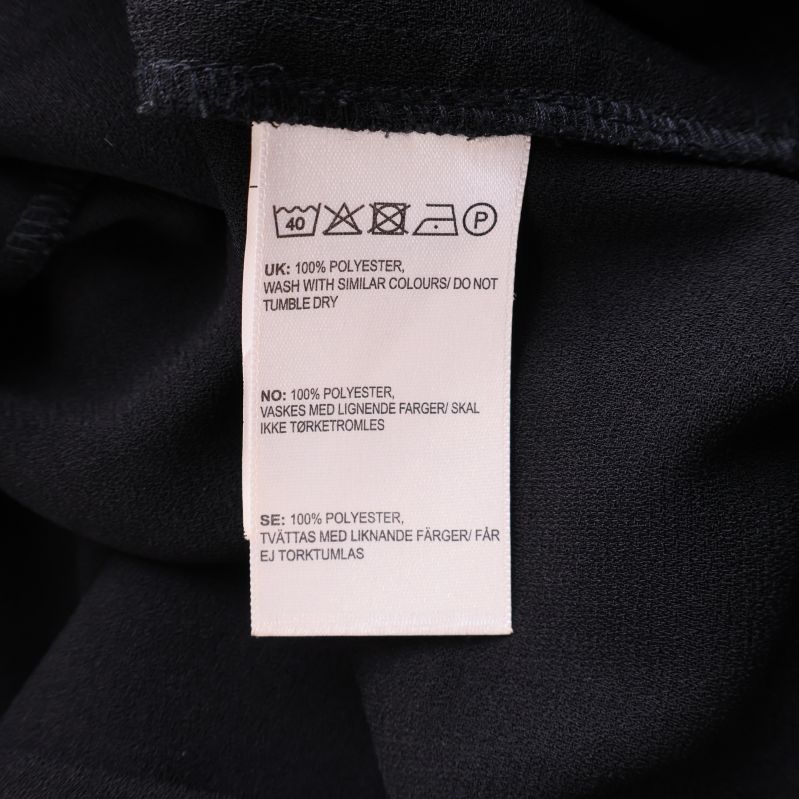 Materiallapp med information om att kappan är av 100% polyester