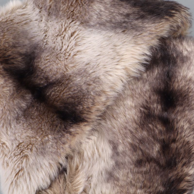 Närbild på mjuka fuskpälsdetaljer i beige och brunt