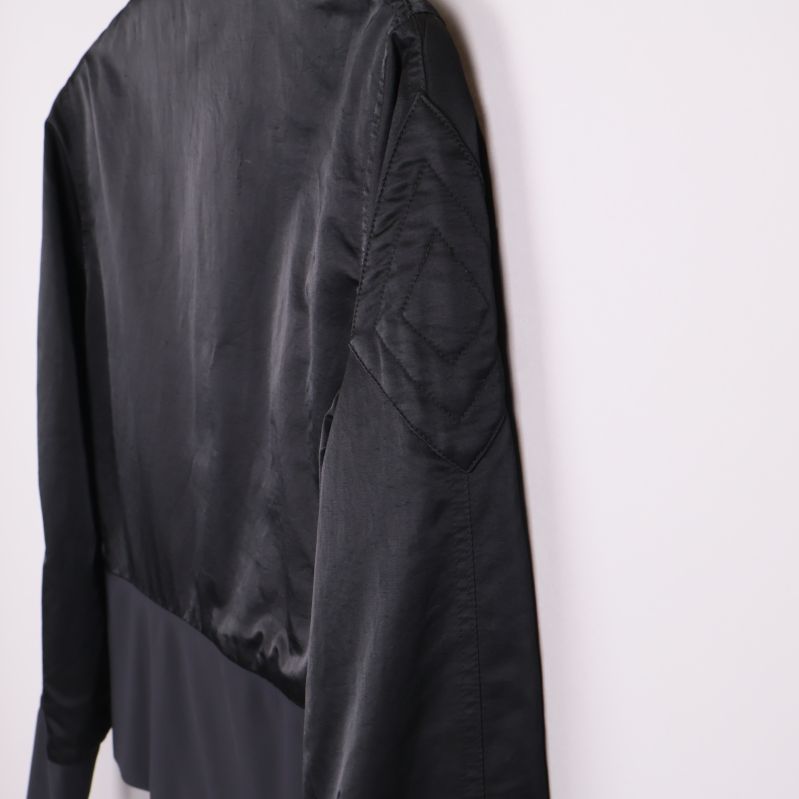 Sidan av jackan med markerad söm och slät svart yta