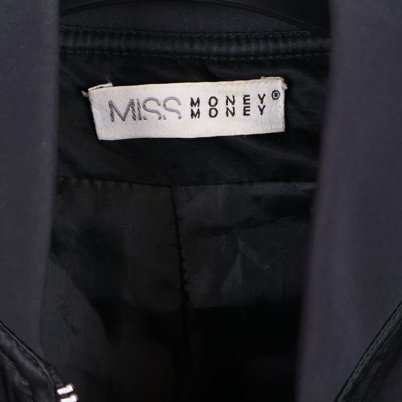 Närbild på etikett med texten MISS MONEY MONEY i jackans krage