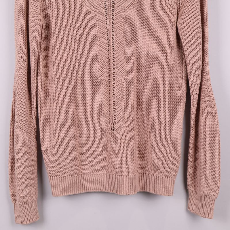 Närbild på ärmar och nederkant av stickad tröja