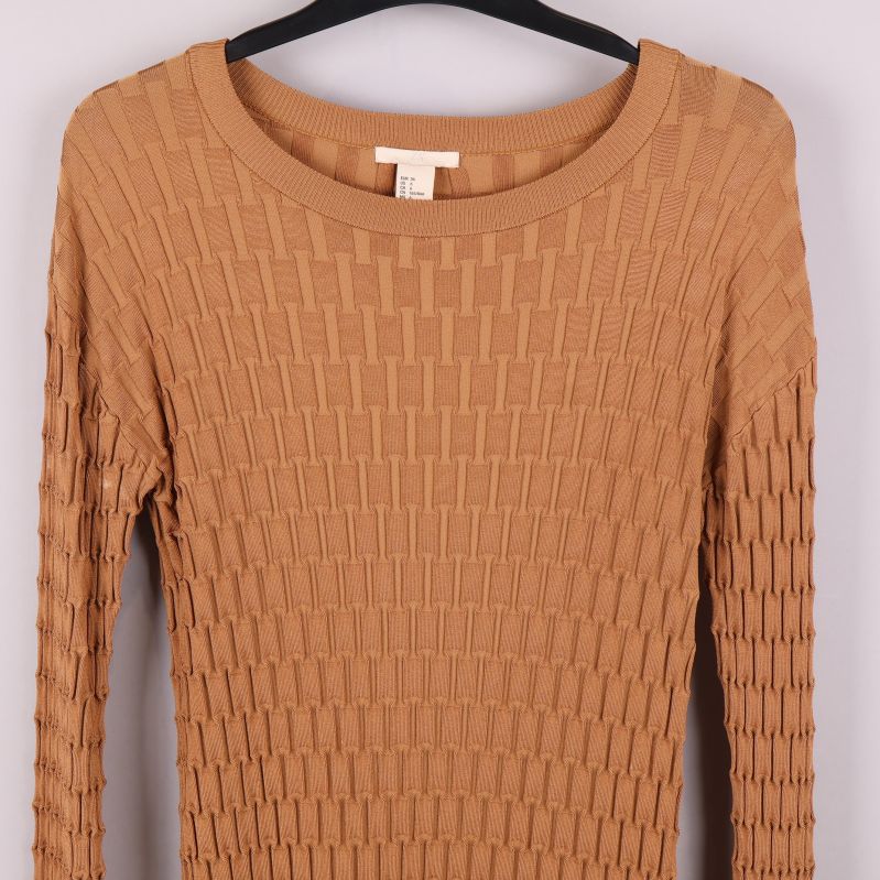 Närbild av övre delen av stickad beige tröja