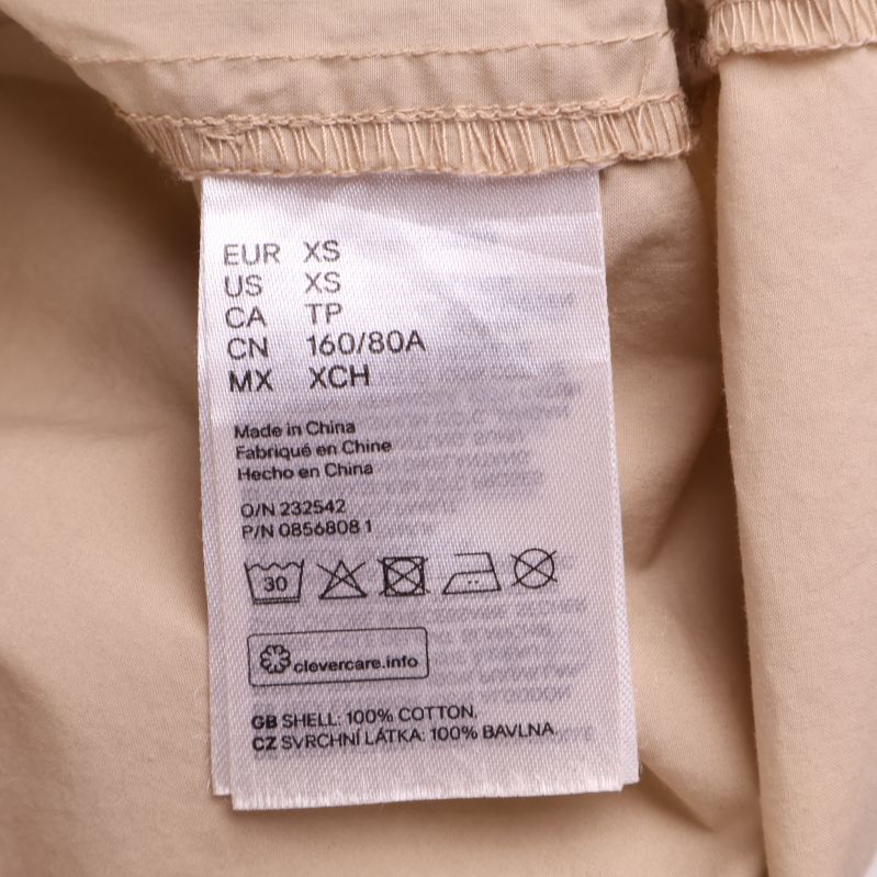 Material- och tvättetikett visar 100% bomull