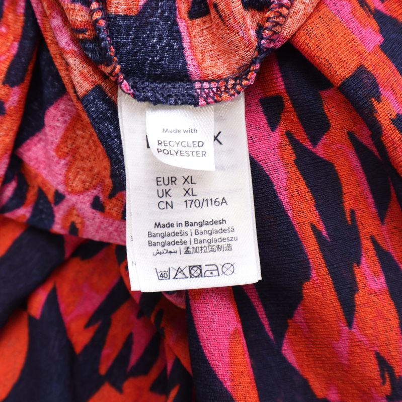 Materialetikett visar återvunnen polyester och storlek XL