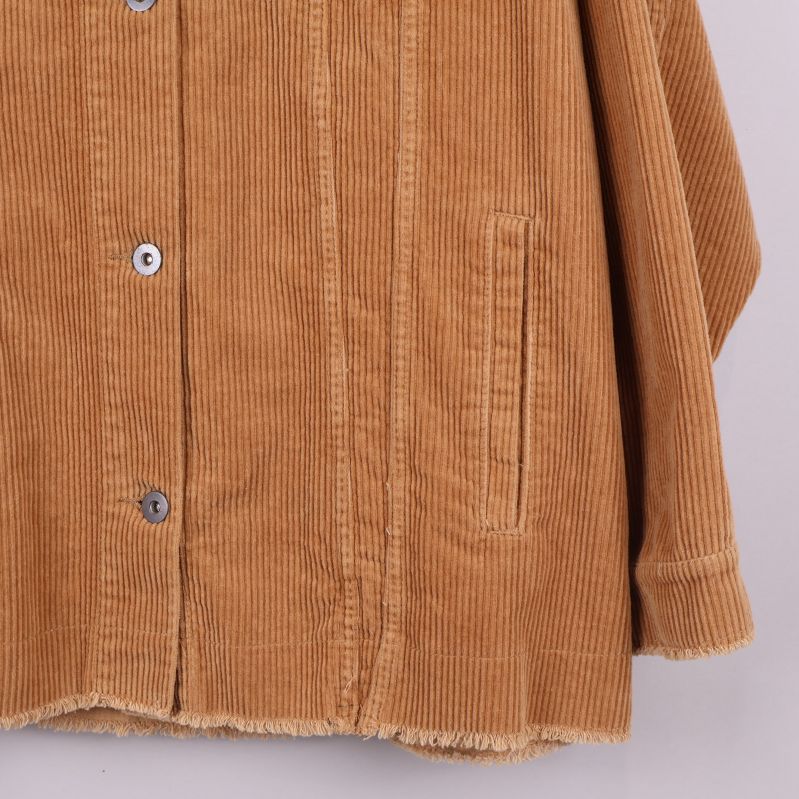 Närbild på nedre delen av jackan med ficka och rå kant