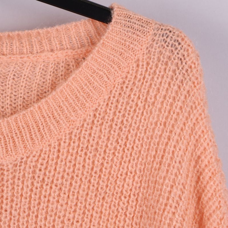 Närbild på halsringning och stickad struktur