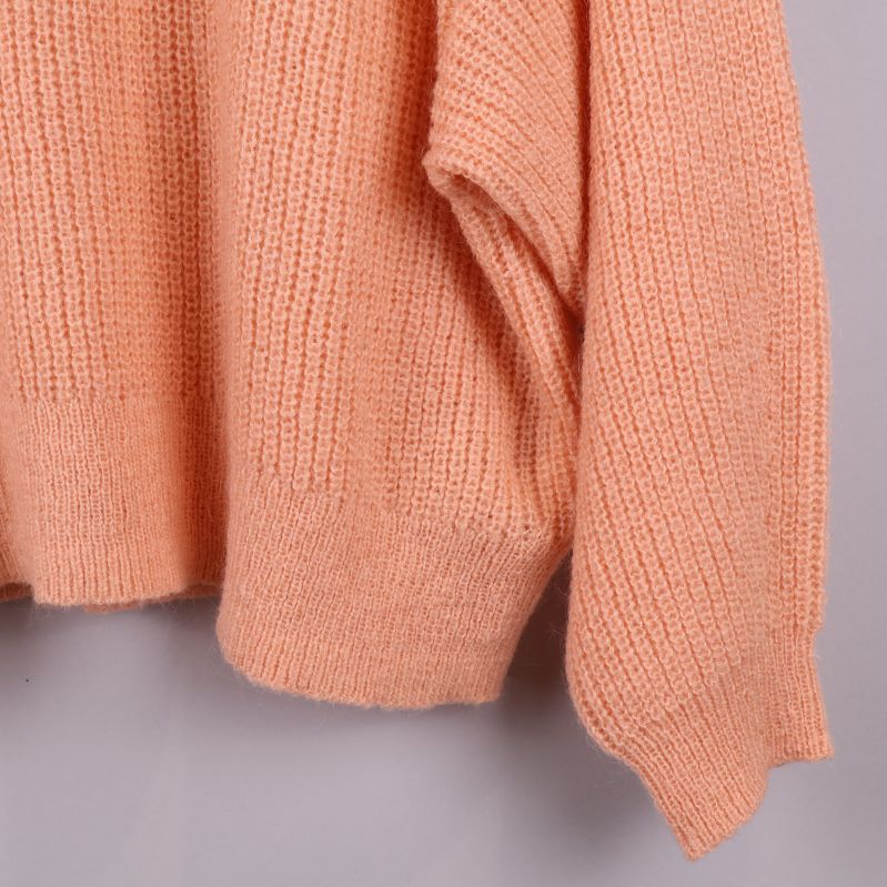 Närbild på nedre delen av tröjans framstycke och ärm