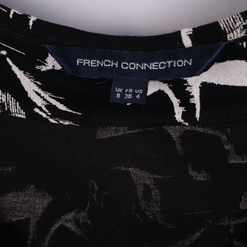 Nära bild på etikett med French Connection logga och storlek