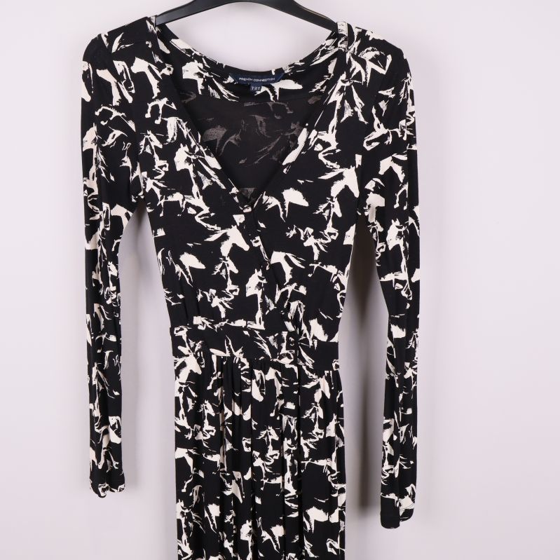 Detaljbild av v-ringning och mönster på klänningens överdel