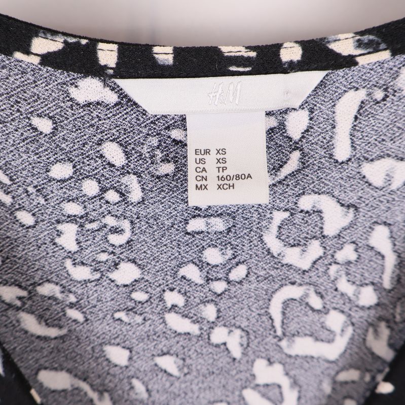 Storlekslapp med texten EUR XS och H&M logga