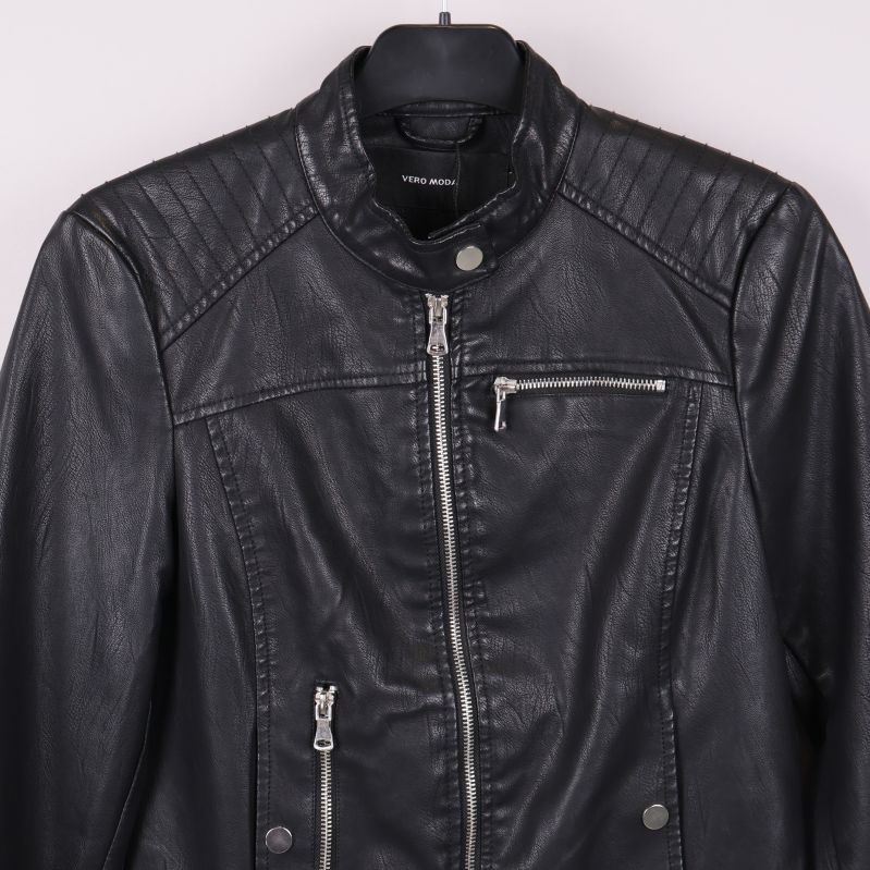 Närbild av axel och dragkedja på svart quiltad jacka