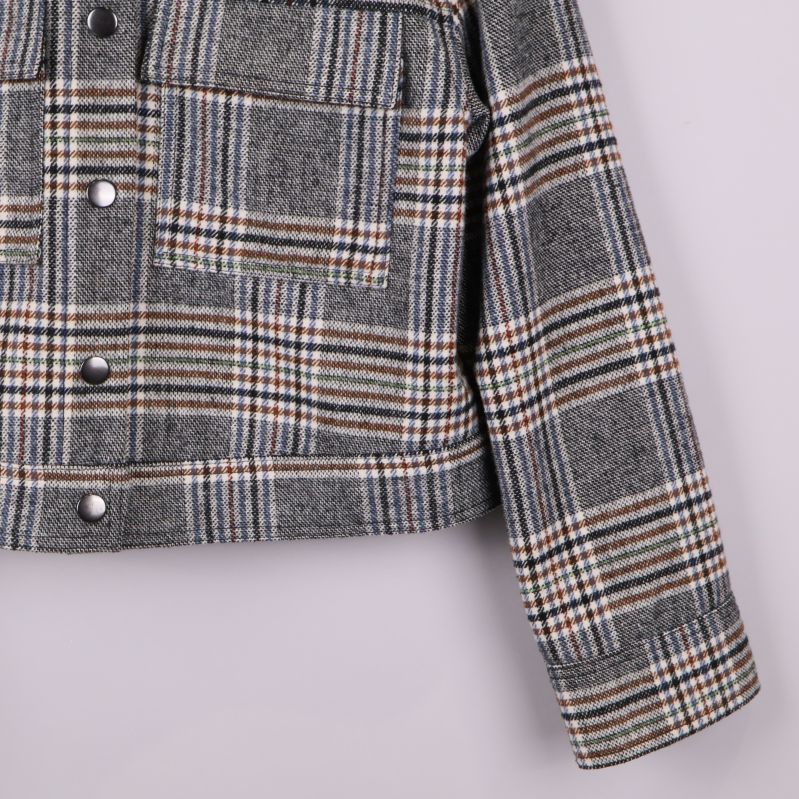 Närbild på ärm och rutigt tyg på jackan