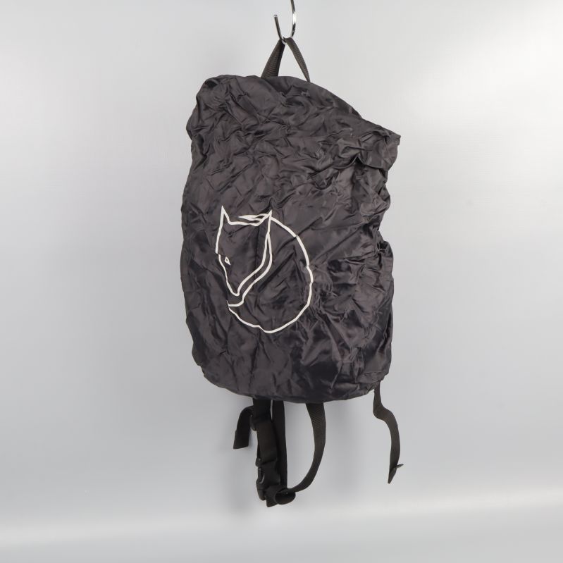 Svart regnskydd på ryggsäck med tecknad rävprofil