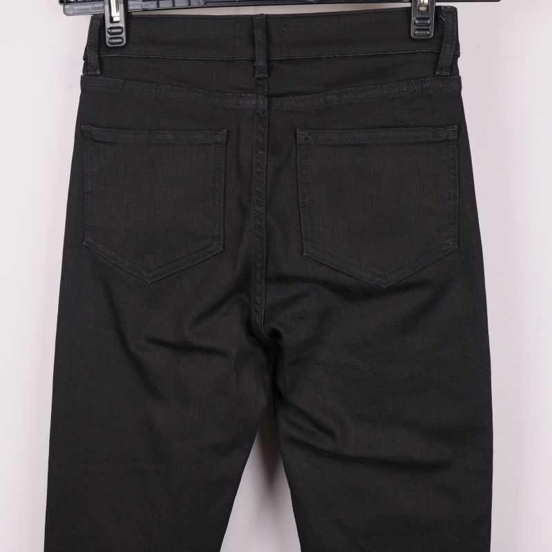 Närbild på bakfickor och linning på svarta jeans