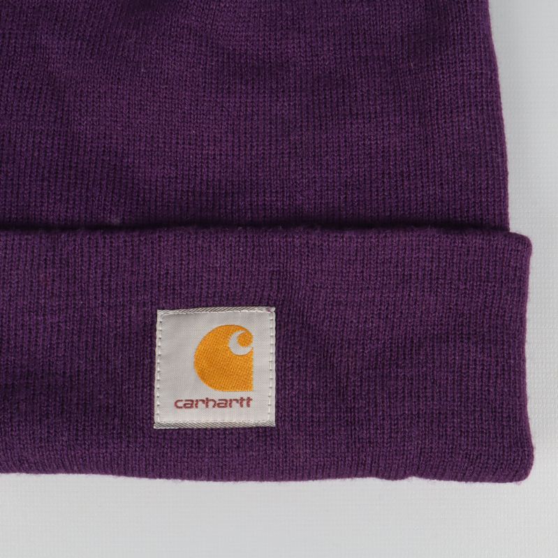Närbild på Carhartt-logotyp på lila mössa